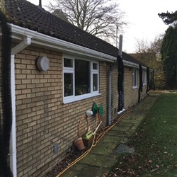 Installing hedgehog gutter guard to prevent build-up of leaves and debris for surrounding trees